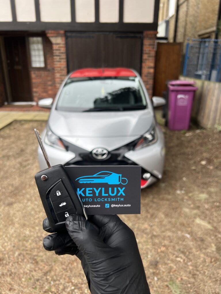 Trusted auto locksmith London technician programming a replacement car key beside a vehicle